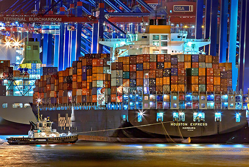 A photo of the 'Houston Express' cargo ship in the port of Hamburg, showing an essential aspect of the supply chain: shipping and logistics.